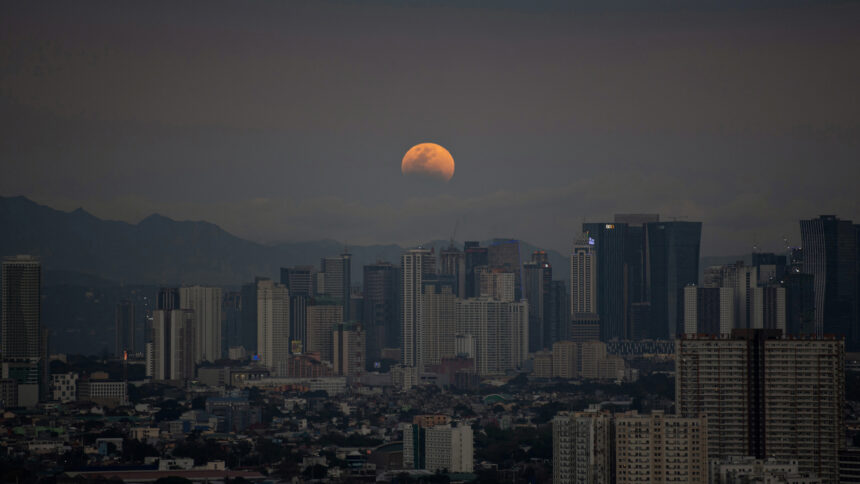 Bulan yang mengalami gerhana terbit di atas Manila yang difoto oleh Ted ALJIBE /Foto: Space