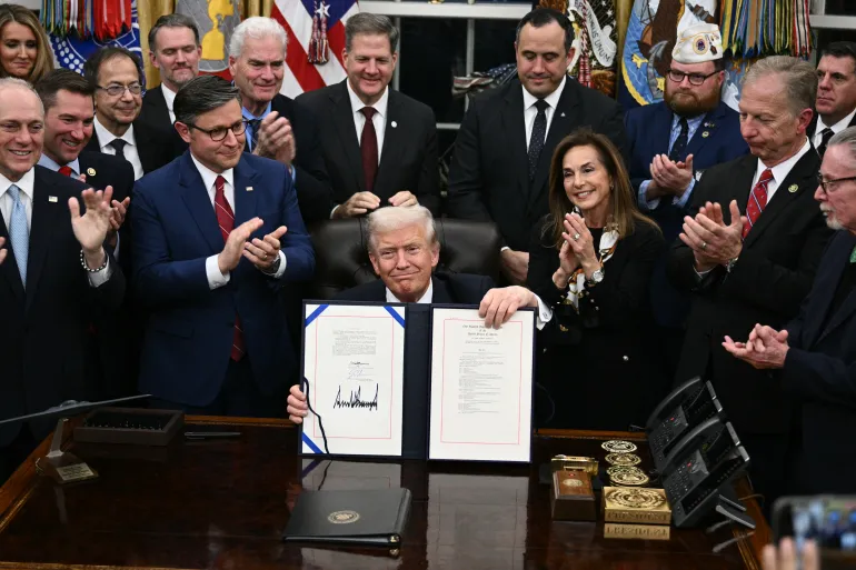 Presiden Donald J Trump dengan RUU yang ditandatangani/ Foto: caption Al Jazeera