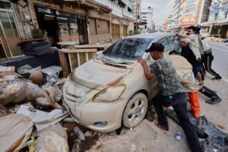 Warga Thailand melakukan pembersihan dampak banjir/ Foto: The Guardian
