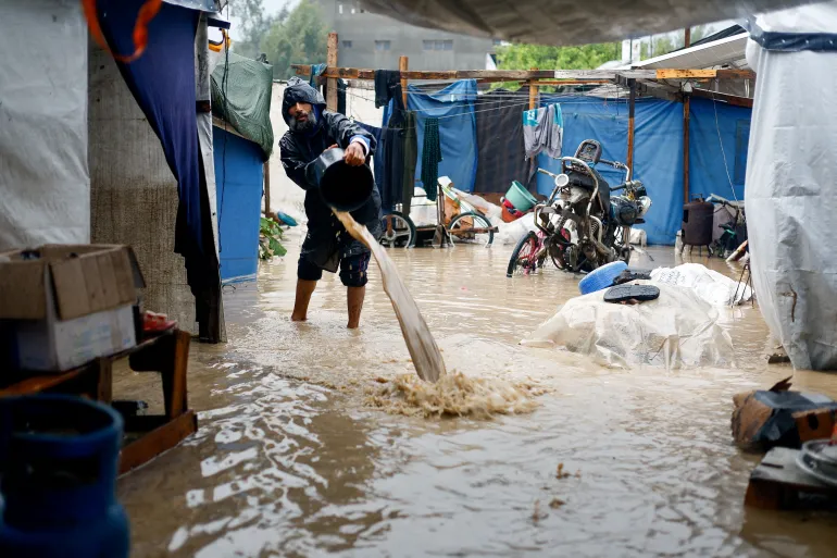 Seorang pria Palestina pengungsi membersihkan air berlumpur di kamp tenda yang tergenang banjir pada hari hujan di Nuseirat, Jalur Gaza tengah/ Foto: capture Al Jazeera