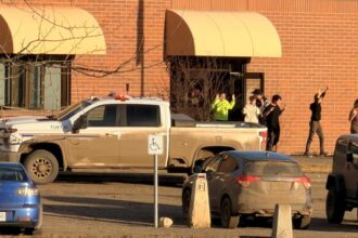 Para siswa berjalan keluar gedung sekolah dengan tangan terangkat setelah seorang penyerang melepaskan tembakan di Tumbler Ridge, British Columbia/ Foto: the guardian