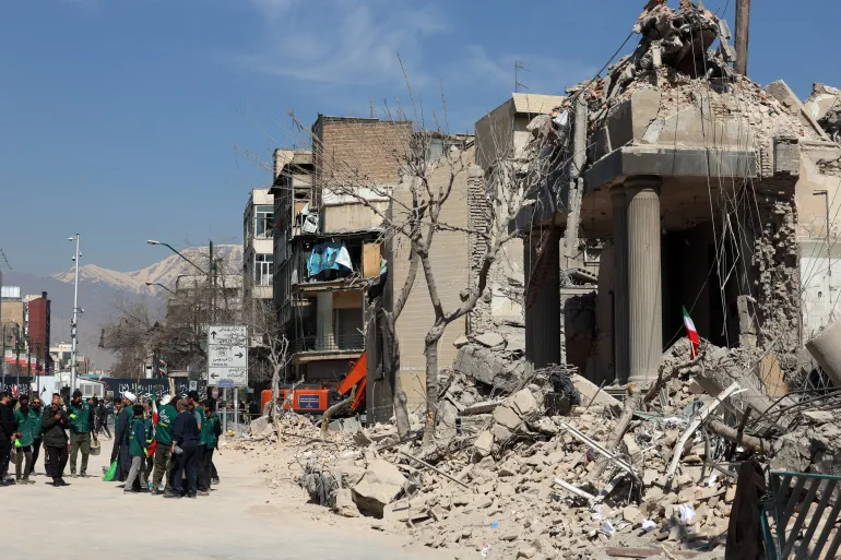 Warga berkumpul di sekitar gedung kantor polisi yang rusak di pusat kota Teheran, Iran/ Foto: aljazeera
