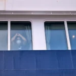 Para penumpang menyaksikan penumpang lain turun dari kapal pesiar MV Hondius yang terjangkit virus hantavirus di pelabuhan Granadilla di Tenerife, Kepulauan Canary, Spanyol/ Foto: APNews