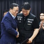 Choi Seung-ho (kanan), kepala serikat pekerja terbesar Samsung Electronics Co., berjabat tangan dengan Yeo Myeong-gu (kiri), kepala tim SDM divisi solusi perangkat Samsung Electronics Co.,/ Foto: Yonhap