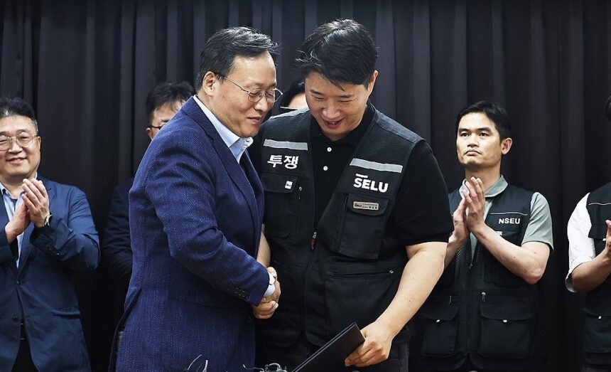 Choi Seung-ho (kanan), kepala serikat pekerja terbesar Samsung Electronics Co., berjabat tangan dengan Yeo Myeong-gu (kiri), kepala tim SDM divisi solusi perangkat Samsung Electronics Co.,/ Foto: Yonhap