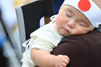 Bayi dengan bando bendera Jepang/ Foto: Anadolu