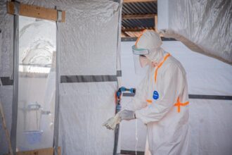 Seorang petugas medis mendisinfeksi sarung tangan pelindung di pusat pengobatan Ebola di Bunia, Provinsi Ituri, Republik Demokratik Kongo/ Foto: xinhua