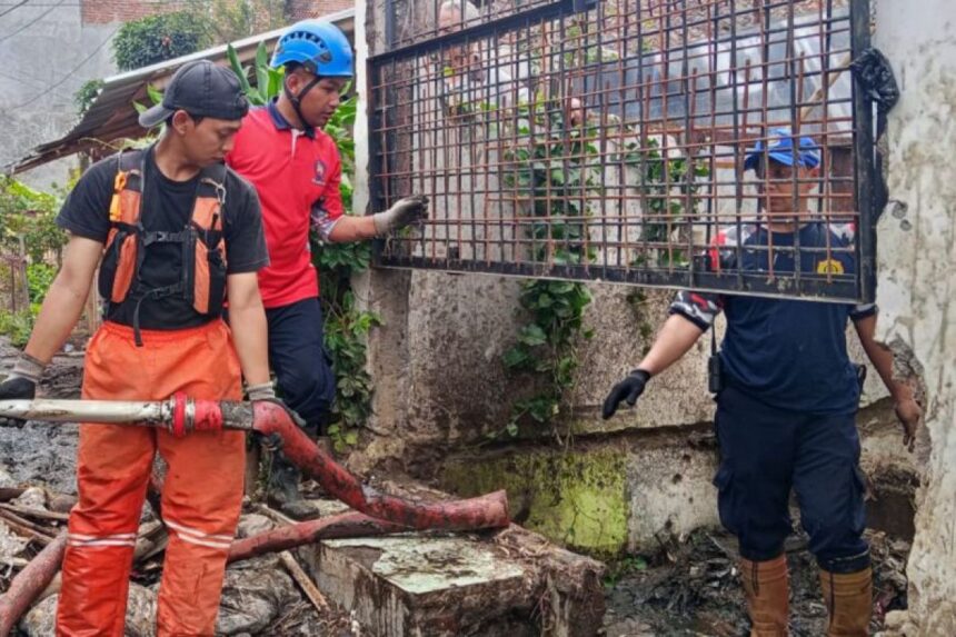 Sejumlah petugas membersihkan sampah yang menyumbat di saluran air/ Foto: ANTARA